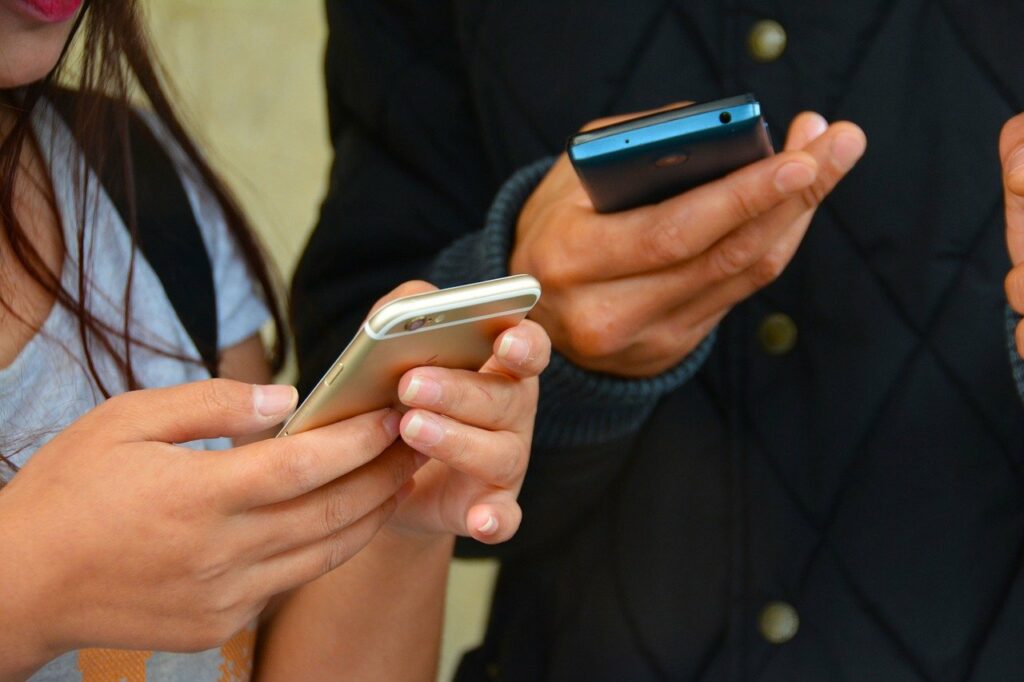 Achtsamkeiten leben und das Handy weglegen: Zwei Personen mit Handy in der Hand